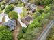 Charming aerial view of a home with mature trees, a circular driveway, and well-manicured landscaping in a desirable neighborhood at 674 Owl Creek Ct, Powder Springs, GA 30127