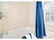 Bathroom tub and shower with a blue curtain and a window with shutters at 674 Owl Creek Ct, Powder Springs, GA 30127