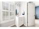 Bathroom with a single vanity, window with shutters, and a doorway to the bedroom at 674 Owl Creek Ct, Powder Springs, GA 30127