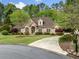 Charming brick home with well-manicured lawn, mature trees, and a circular driveway at 674 Owl Creek Ct, Powder Springs, GA 30127