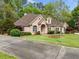 Attractive brick home with a well-kept lawn, mature trees, and a welcoming front entrance at 674 Owl Creek Ct, Powder Springs, GA 30127