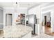 Modern kitchen featuring a pantry, stainless steel refrigerator, and granite countertops at 674 Owl Creek Ct, Powder Springs, GA 30127