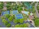 Aerial view of a community with tennis courts, a pool, and a pond surrounded by lush greenery and well-maintained homes at 7020 Grand View Way, Suwanee, GA 30024