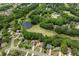 Aerial shot of homes nestled in lush greenery near a golf course and pond, showing a beautiful community at 7020 Grand View Way, Suwanee, GA 30024