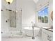 Luxurious bathroom with glass shower, standalone tub and view through bright window at 7020 Grand View Way, Suwanee, GA 30024