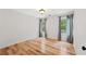 Well-lit bedroom with hardwood floors, light walls and two windows with decorative curtains at 7020 Grand View Way, Suwanee, GA 30024