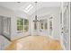 Bright breakfast nook featuring hardwood floors, skylight, large windows with backyard views and stylish light fixture at 7020 Grand View Way, Suwanee, GA 30024