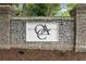 Stone entrance to Olde Atlanta Club features the community's emblem on a white sign, surrounded by lush greenery at 7020 Grand View Way, Suwanee, GA 30024