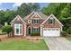 Charming brick two-story home with well-manicured lawn and a two-car garage at 7020 Grand View Way, Suwanee, GA 30024