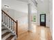 Bright foyer featuring hardwood floors, staircase, and a view into the formal dining area at 7020 Grand View Way, Suwanee, GA 30024