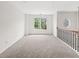 Bright, spacious hallway featuring neutral carpeting and a large window overlooking the outdoors at 7020 Grand View Way, Suwanee, GA 30024