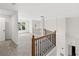 Upstairs hallway boasting wood railing, an oval window and neutral walls and carpet at 7020 Grand View Way, Suwanee, GA 30024