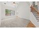 Bright living room with high ceilings, a ceiling fan, large windows, and staircase at 7020 Grand View Way, Suwanee, GA 30024