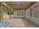 Back patio with wood pergola, built-in lighting and a view of the lush backyard at 7020 Grand View Way, Suwanee, GA 30024