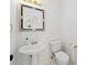 Charming powder room with pedestal sink and decorative mirror at 7020 Grand View Way, Suwanee, GA 30024