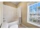 This is a view of the bathroom tub/shower combo with an updated shower curtain and a window at 1250 Parkwood Se Cir # 300, Atlanta, GA 30339