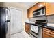 Compact kitchen featuring stainless steel appliances, black countertops, and wood cabinets at 1250 Parkwood Se Cir # 300, Atlanta, GA 30339