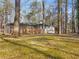 The backyard has a large lawn, mature trees, and a screened porch attached to the house at 2019 Emerald Dr, Jonesboro, GA 30236