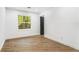 Minimalist bedroom featuring laminate flooring, a large window with a wooded view, and neutral white walls at 2019 Emerald Dr, Jonesboro, GA 30236