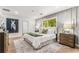 Bright bedroom featuring stylish accent wall, queen bed, and two nightstands with drawers overlooking a window with a wooded view at 2019 Emerald Dr, Jonesboro, GA 30236