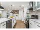 Bright modern kitchen with white cabinets, stainless steel appliances, marble backsplash, and wood grain flooring at 2019 Emerald Dr, Jonesboro, GA 30236