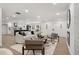 Open concept living room with white sofa, brick fireplace, and views of the modern kitchen and entry doors at 2019 Emerald Dr, Jonesboro, GA 30236