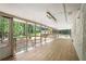 This spacious sunroom features wood-style floors, a wall of windows, and views of the backyard and surrounding trees at 2019 Emerald Dr, Jonesboro, GA 30236