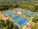 This aerial view features multiple well-maintained tennis courts surrounded by trees and greenery in a park-like setting at 2019 Emerald Dr, Jonesboro, GA 30236