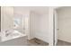 Bright bathroom with double sinks, a soaking tub, and an open door to the walk-in closet at 349 Elgin Dr, Lawrenceville, GA 30045