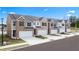 A street view of townhomes displays brick and siding exteriors, garages, and landscaped yards at 349 Elgin Dr, Lawrenceville, GA 30045