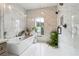 A modern bathroom features a soaking tub, a glass-enclosed shower, and floor to ceiling marble-style tile at 3667 Peachtree Ne Rd # 6, Atlanta, GA 30319