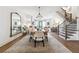 Open-concept dining room featuring a large table, modern chandelier, and a view into the living room and staircase at 3667 Peachtree Ne Rd # 6, Atlanta, GA 30319