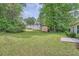 Large backyard with a storage shed and lush green trees at 7112 Greenway Sw Cv, Covington, GA 30014