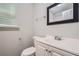 Bright bathroom featuring white vanity, toilet, and framed mirror over the sink at 7112 Greenway Sw Cv, Covington, GA 30014