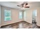Bedroom featuring two windows, wood plank flooring and a ceiling fan at 7112 Greenway Sw Cv, Covington, GA 30014
