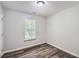 Bedroom featuring wood plank flooring, white walls and a window with blinds at 7112 Greenway Sw Cv, Covington, GA 30014