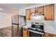 Kitchen featuring stainless steel refrigerator and oven and oak cabinets at 7112 Greenway Sw Cv, Covington, GA 30014