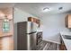 Galley kitchen featuring stainless steel appliances, wood cabinets and gray wood flooring at 7112 Greenway Sw Cv, Covington, GA 30014