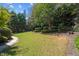 Spacious backyard with lush green lawn, mature trees, and manicured shrubbery at 8715 Islesworth Ct, Duluth, GA 30097