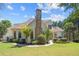 Spacious backyard featuring lush green grass, mature trees, and a charming stone fireplace on the house's rear at 8715 Islesworth Ct, Duluth, GA 30097