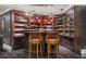 Custom-built bar and wine cellar featuring glass display cases and red lighting at 8715 Islesworth Ct, Duluth, GA 30097