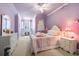 Inviting bedroom with lilac walls, plush carpet, and a charming array of whimsical decorations at 8715 Islesworth Ct, Duluth, GA 30097