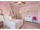 Bright pink bedroom with crown molding, ceiling fan, and walk-in closet at 8715 Islesworth Ct, Duluth, GA 30097
