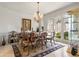 Traditional dining room with a chandelier, large window, and classic furnishings with an area rug at 8715 Islesworth Ct, Duluth, GA 30097