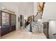 Elegant foyer with a staircase, travertine floors, and stone accents on the front door surround at 8715 Islesworth Ct, Duluth, GA 30097