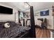 Bedroom featuring a black canopy bed, wood-look flooring, and a TV at 151 Grandma Branch Rd, Grantville, GA 30220