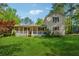 Charming two-story home with a front porch, situated on a grassy lot surrounded by mature trees at 151 Grandma Branch Rd, Grantville, GA 30220