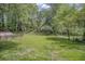 Fenced backyard with lush, green grass and mature trees at 1528 Alder Sw Ln, Atlanta, GA 30311