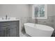 Bright bathroom with standalone tub, marble accent wall, and vanity with modern fixtures at 1528 Alder Sw Ln, Atlanta, GA 30311