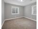 Neutral bedroom with two windows allowing for ample natural light and neutral carpet at 1528 Alder Sw Ln, Atlanta, GA 30311
